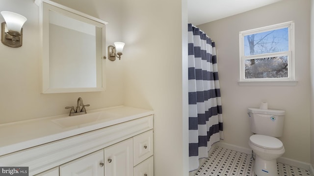 bathroom featuring toilet, vanity, and walk in shower