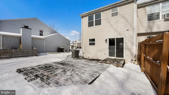 snow covered back of property featuring central air condition unit