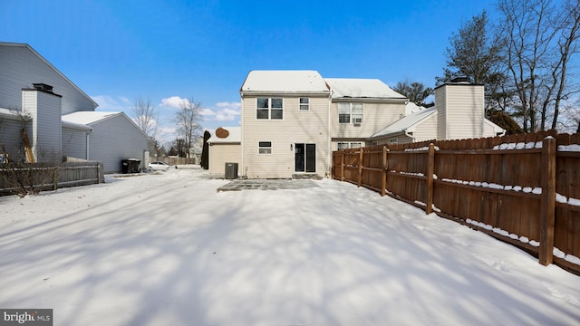 snow covered house with central AC