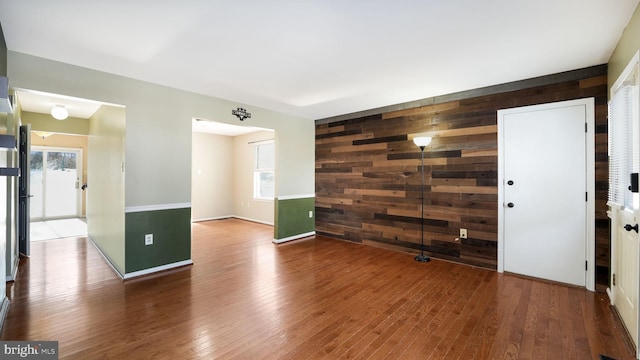 spare room featuring hardwood / wood-style flooring and wooden walls