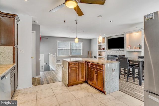 kitchen with hanging light fixtures, appliances with stainless steel finishes, built in features, and light tile patterned flooring