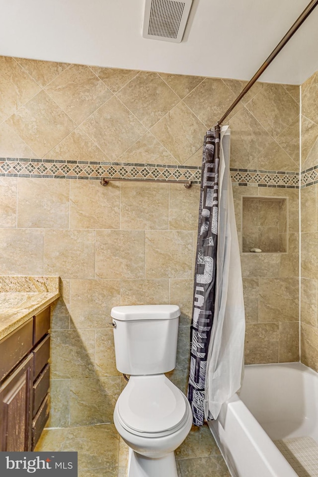 full bathroom featuring toilet, tile walls, shower / bathtub combination with curtain, and vanity