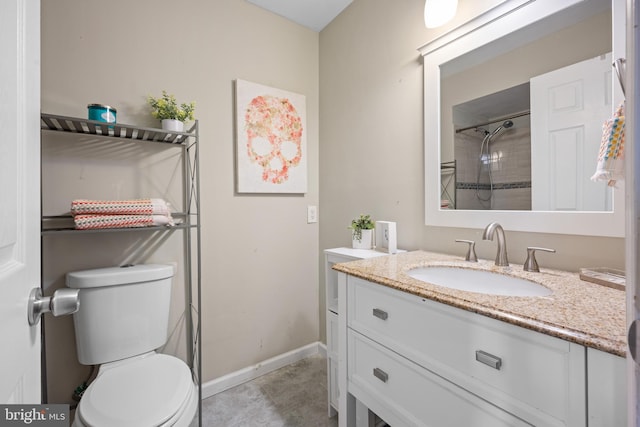 bathroom featuring a tile shower, vanity, tile patterned floors, and toilet