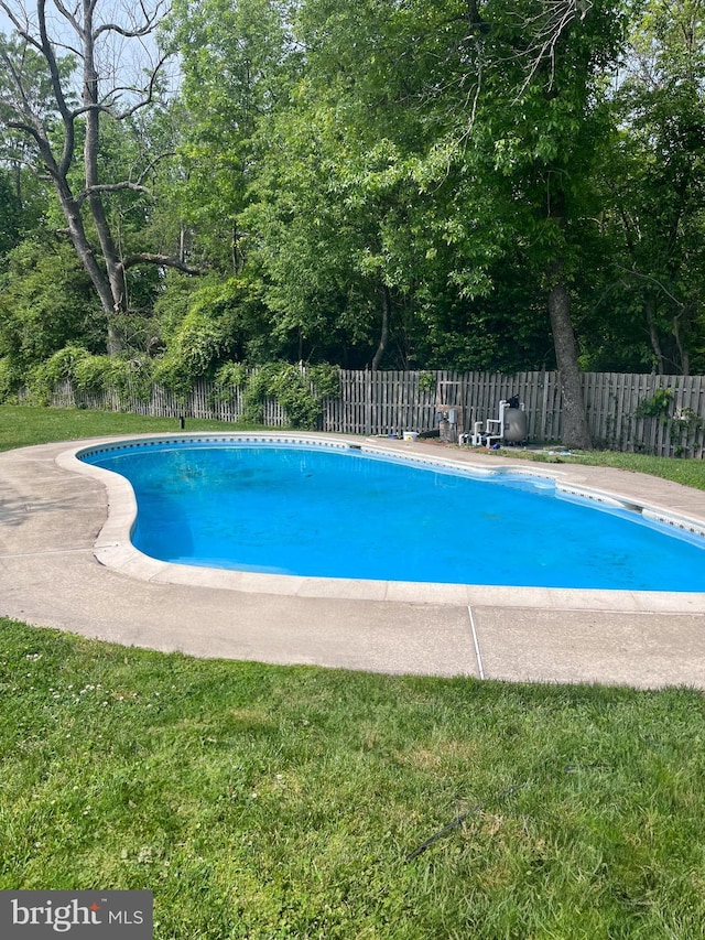 view of pool with a lawn