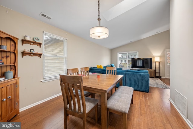 dining space featuring lofted ceiling, a wealth of natural light, and light hardwood / wood-style flooring