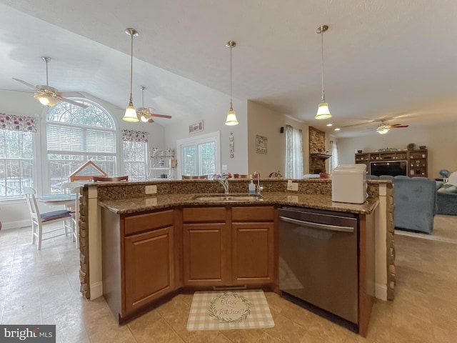 kitchen with stone counters, vaulted ceiling, dishwasher, sink, and hanging light fixtures