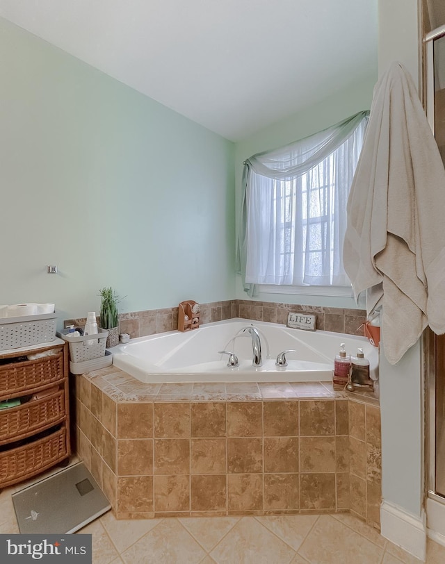 bathroom with tiled bath and tile patterned floors