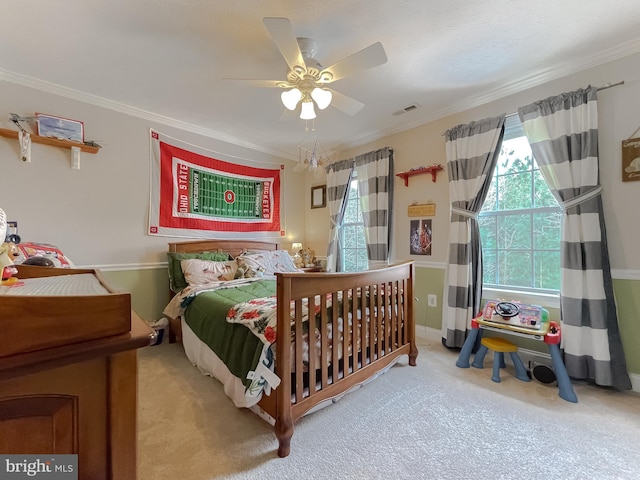 carpeted bedroom featuring ornamental molding and ceiling fan