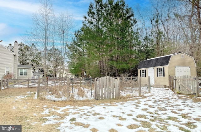 yard layered in snow featuring a shed