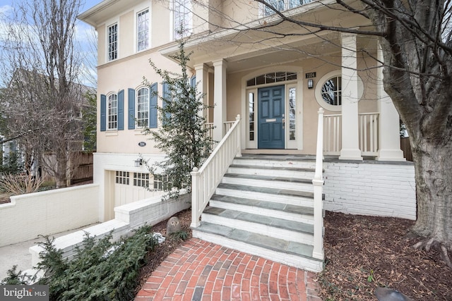 view of exterior entry with brick siding and stucco siding