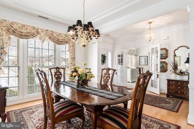 dining room featuring a notable chandelier, a wealth of natural light, and light hardwood / wood-style flooring