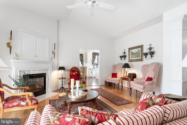 living room with a premium fireplace, ceiling fan, and light hardwood / wood-style flooring