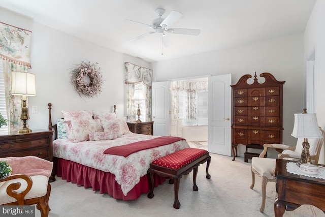 carpeted bedroom with ensuite bath and ceiling fan