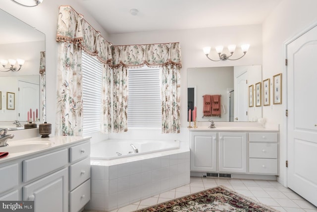 bathroom featuring tile patterned flooring, tiled tub, and vanity