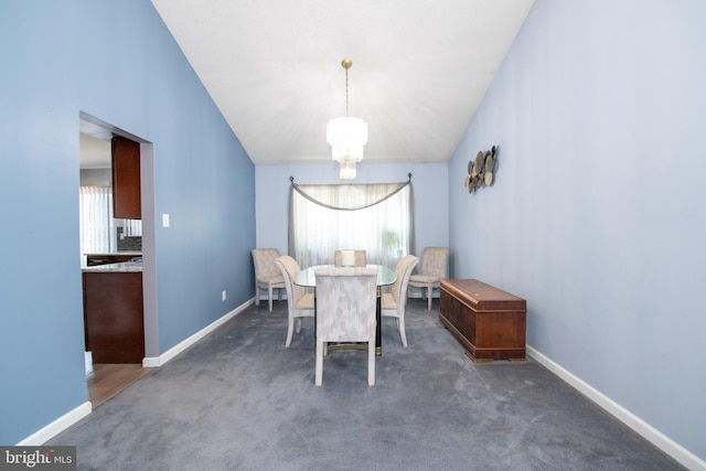 dining room with lofted ceiling, plenty of natural light, a chandelier, and dark colored carpet