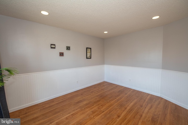 spare room featuring hardwood / wood-style flooring and a textured ceiling