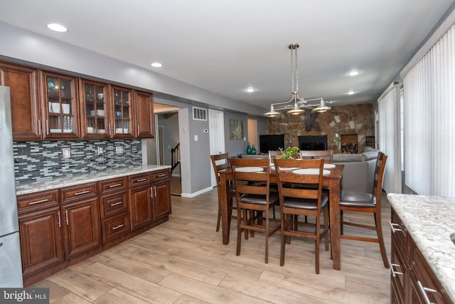 dining space featuring a fireplace and light hardwood / wood-style floors