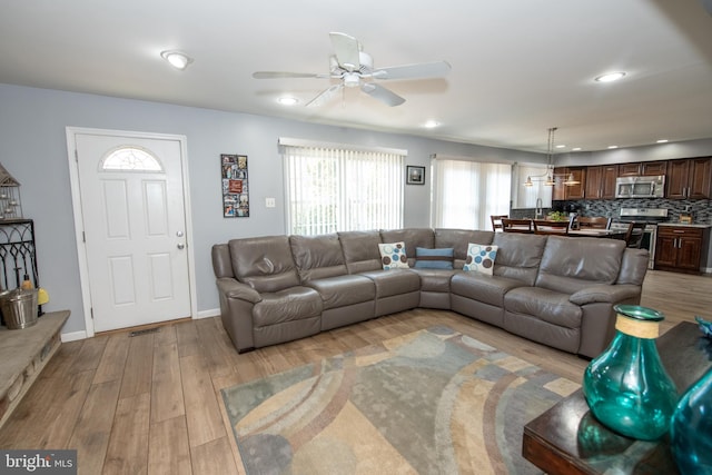 living room with ceiling fan and light wood-type flooring