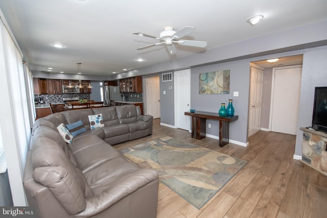 living room featuring wood-type flooring and ceiling fan