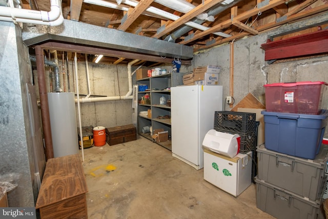 basement with water heater and white refrigerator