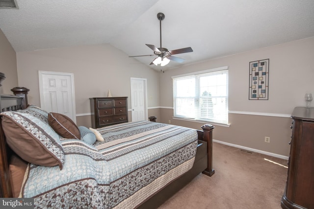 carpeted bedroom featuring a textured ceiling, vaulted ceiling, and ceiling fan