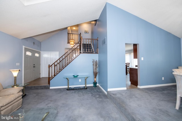 foyer with dark carpet and high vaulted ceiling