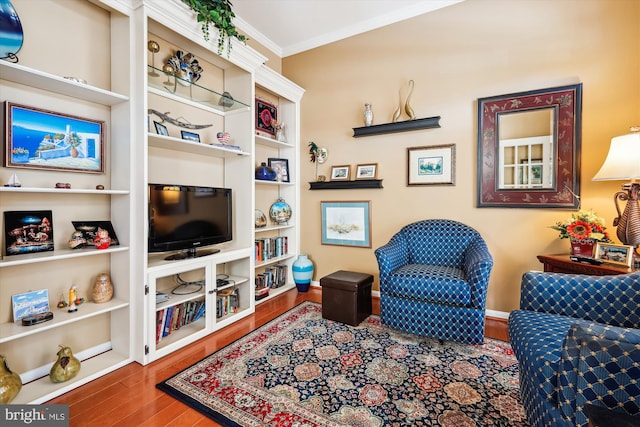 sitting room featuring wood-type flooring and crown molding