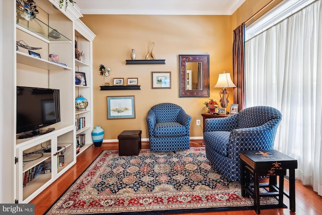 sitting room with hardwood / wood-style flooring, crown molding, and a healthy amount of sunlight