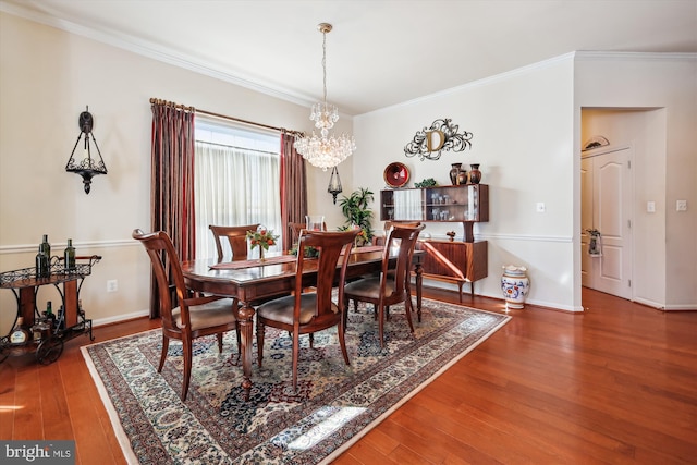 dining room with crown molding, an inviting chandelier, and wood-type flooring