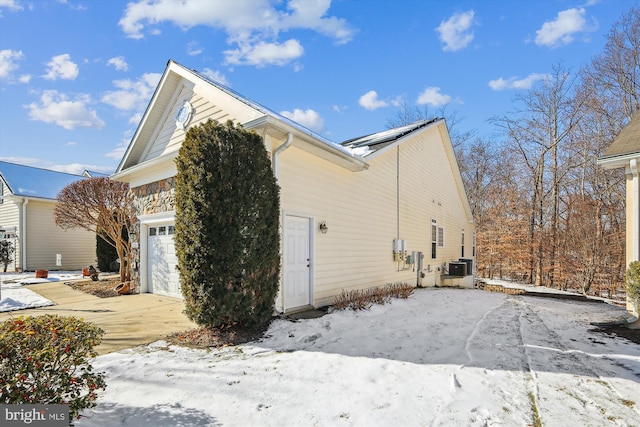 snow covered property with a garage