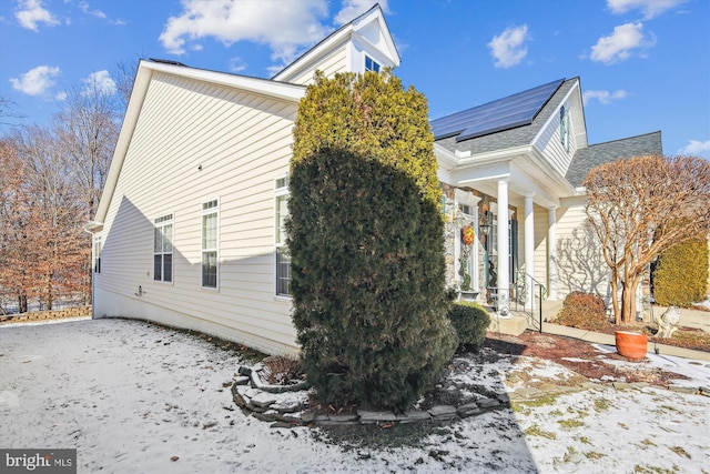 snow covered property featuring solar panels