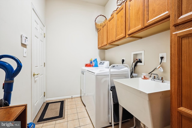 washroom featuring cabinets, light tile patterned floors, sink, and independent washer and dryer