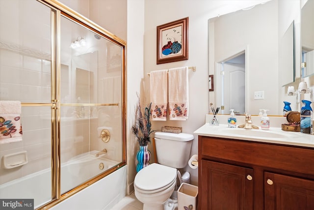 full bathroom with enclosed tub / shower combo, vanity, and toilet