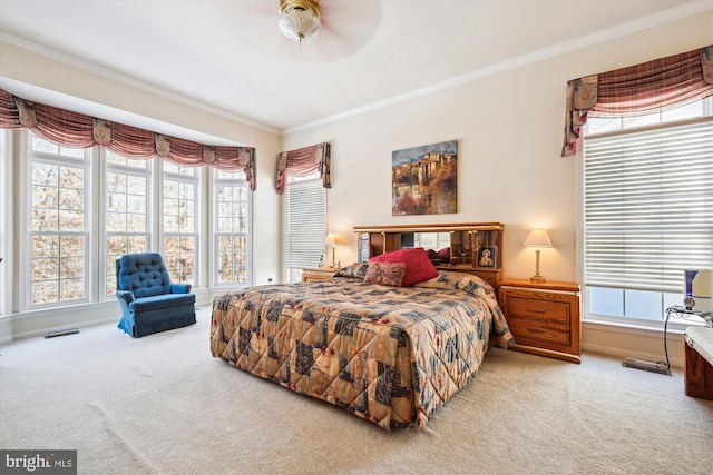 bedroom with ceiling fan, crown molding, and carpet floors