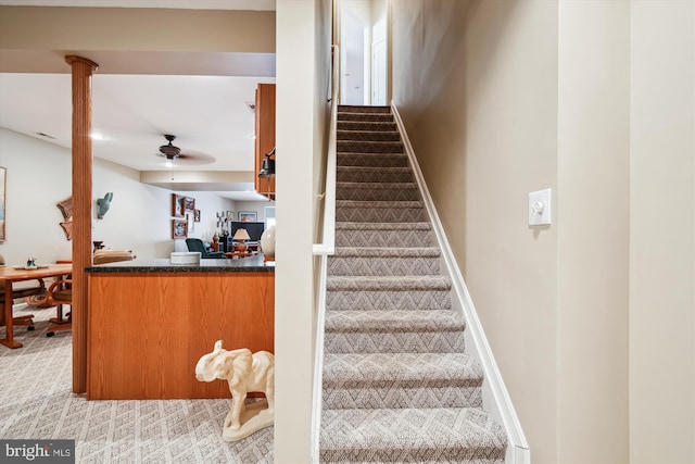 stairway with carpet floors and ceiling fan