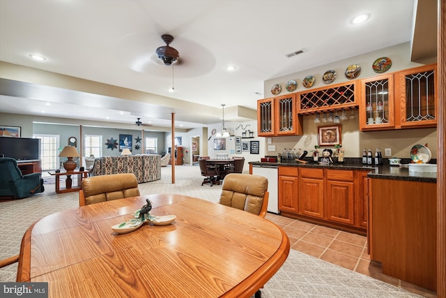 tiled dining area featuring ceiling fan and indoor bar