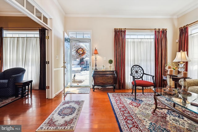 foyer entrance with ornamental molding and dark wood-type flooring