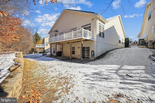 snow covered property with a wooden deck