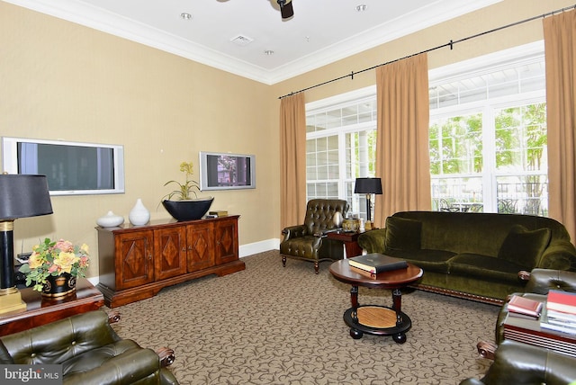 living room with carpet floors, a wealth of natural light, ornamental molding, and ceiling fan