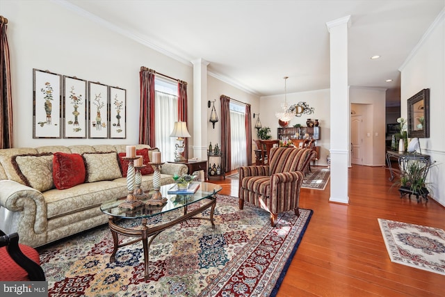 living room featuring ornamental molding, hardwood / wood-style flooring, and ornate columns