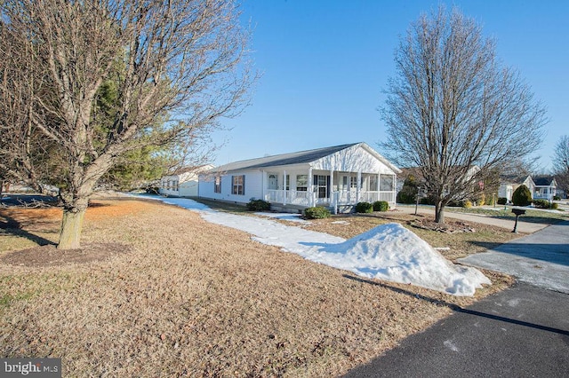 ranch-style house featuring a porch and a front lawn