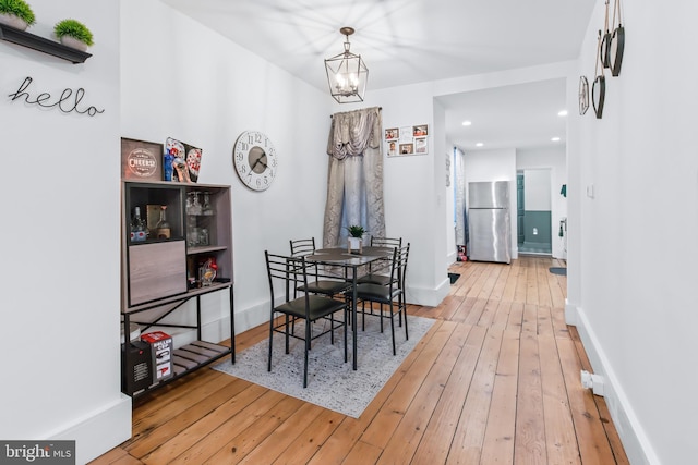 dining area with an inviting chandelier and wood-type flooring