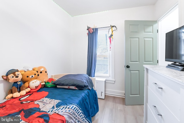 bedroom with multiple windows and light wood-type flooring