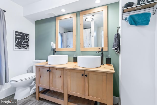 bathroom featuring vanity, hardwood / wood-style floors, and toilet