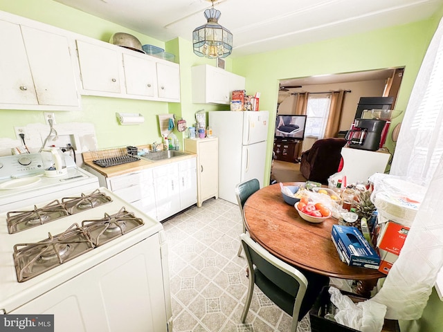 kitchen with hanging light fixtures, white cabinetry, sink, and white appliances