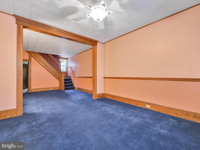 basement with ceiling fan and dark carpet