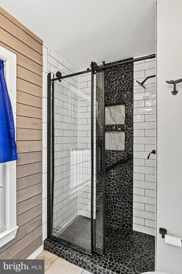 bathroom featuring walk in shower, tile patterned flooring, and wood walls