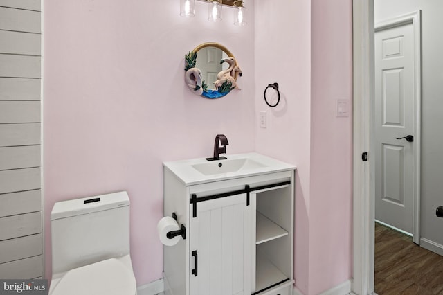 bathroom with vanity, hardwood / wood-style flooring, and toilet