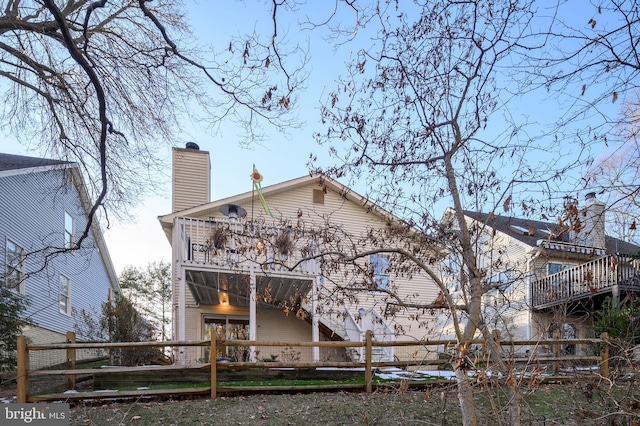 back of property featuring a balcony and a deck