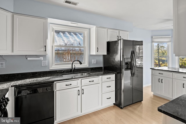 kitchen with dishwasher, sink, white cabinets, dark stone counters, and stainless steel fridge with ice dispenser